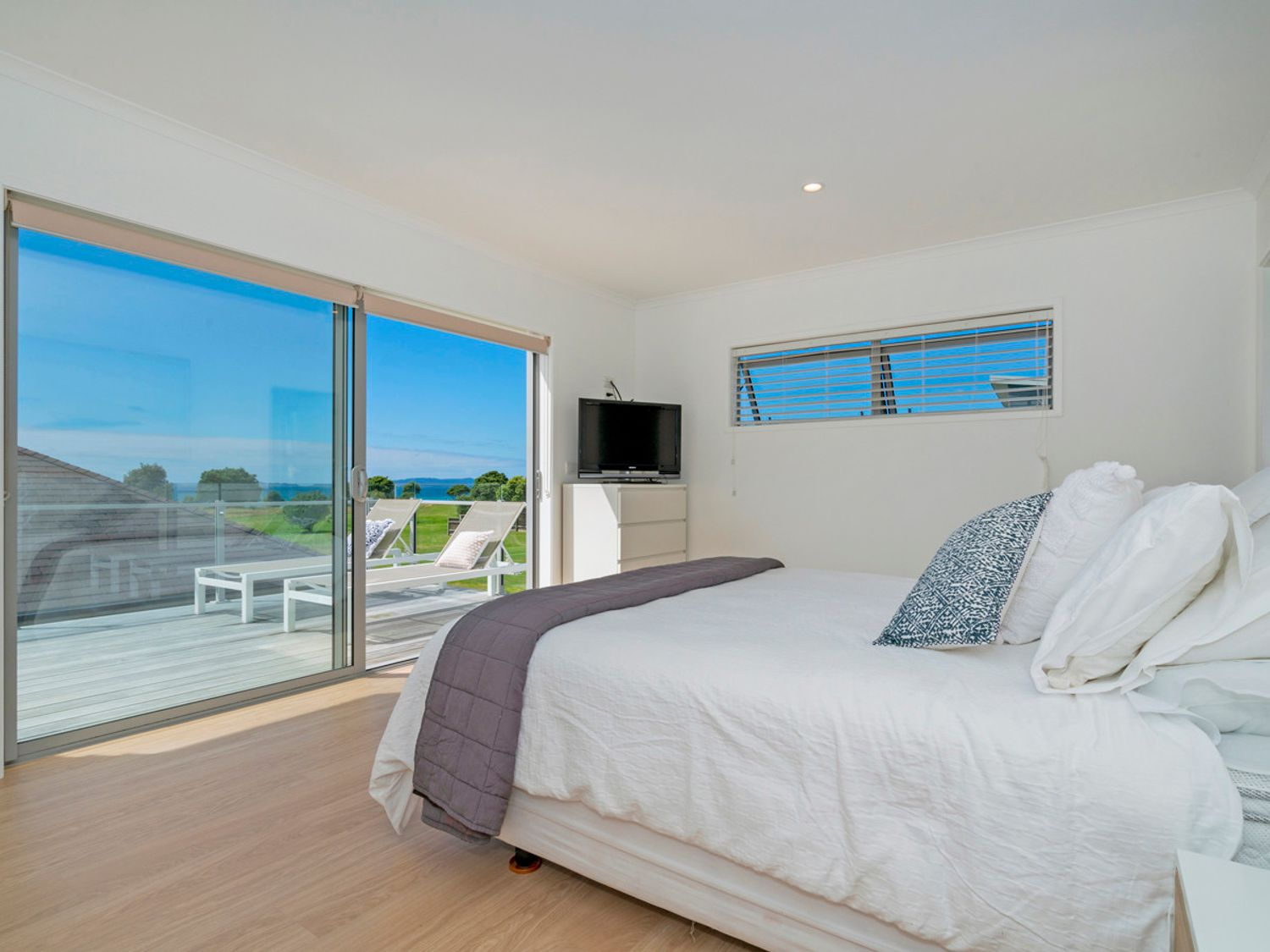 Calm coastal bedroom with natural linen at Coastal Pearl Matarangi